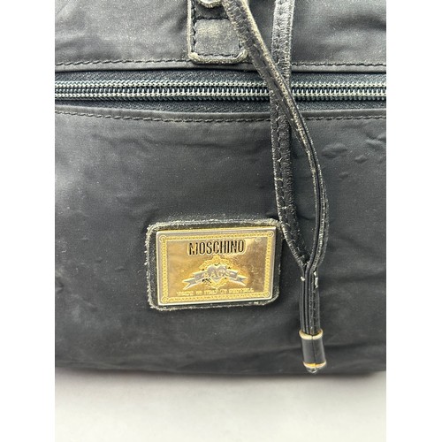 43 - A VINTAGE MOSCHINO BACKPACK RUCKSACK, black with gold hardware spelling out 'Moschino' with various ... 