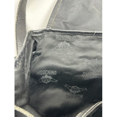 43 - A VINTAGE MOSCHINO BACKPACK RUCKSACK, black with gold hardware spelling out 'Moschino' with various ... 