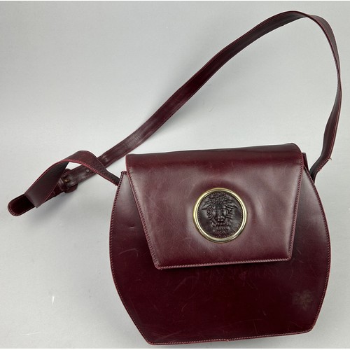 28 - A VINTAGE VERSACE BURGUNDY LEATHER FLAP BAG, with central Medusa head emblem and leather strap.

26c... 