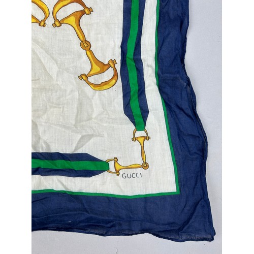 123 - A VINTAGE GUCCI SILK SCARF, equestrian interest with horses bridles.

52cm x 52cm

Good vintage cond... 