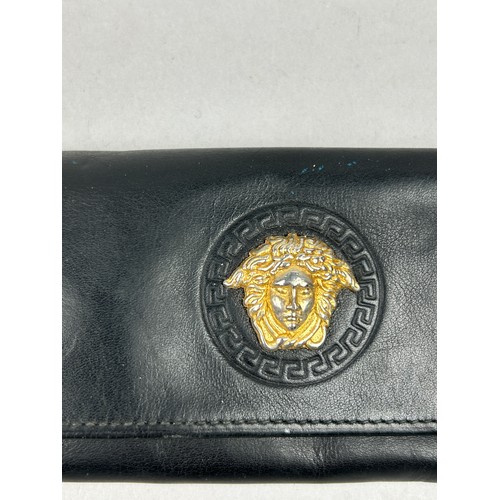 59 - A VERSACE BLACK LEATHER WALLET, with gold coloured hardware