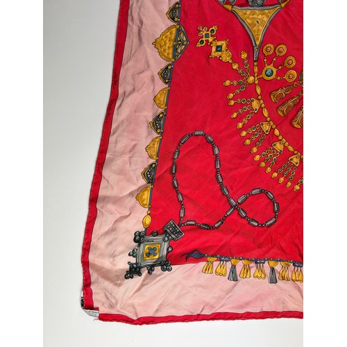 132 - A LARGE VINTAGE HERMES SILK SCARF, red, gold and pink depicting various articles of archaic jeweller... 