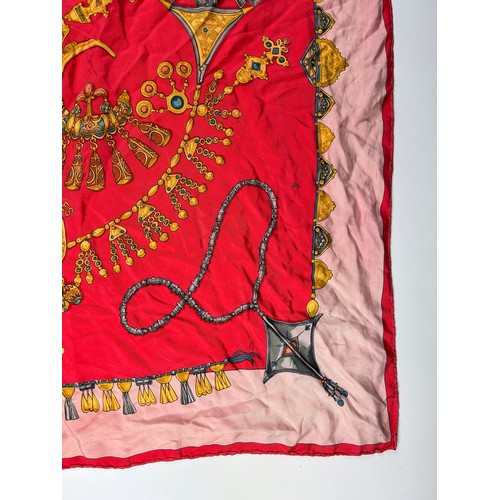 132 - A LARGE VINTAGE HERMES SILK SCARF, red, gold and pink depicting various articles of archaic jeweller... 