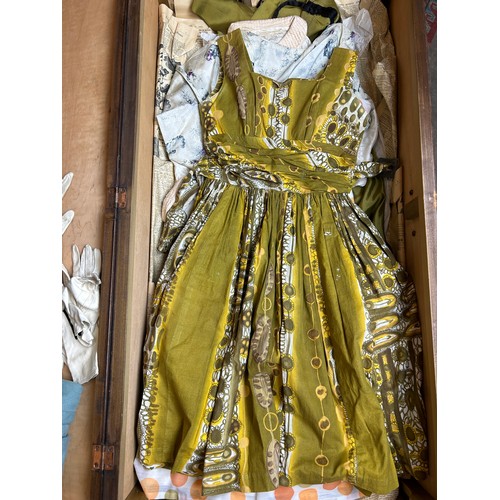 153 - A LARGE TRAVEL WARDROBE ON CASTORS CONTAINING DRESSES AND OUTFITS FROM THE 1940's-1960's including l... 