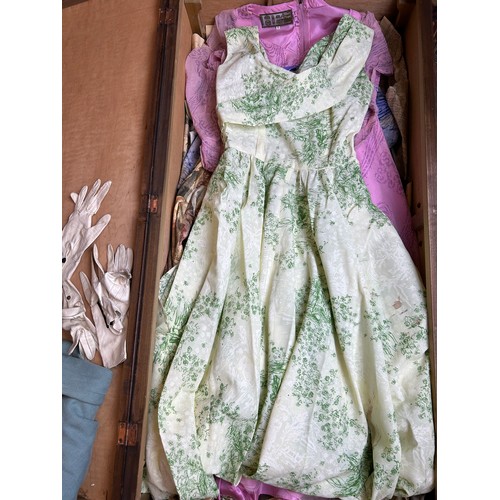 153 - A LARGE TRAVEL WARDROBE ON CASTORS CONTAINING DRESSES AND OUTFITS FROM THE 1940's-1960's including l... 