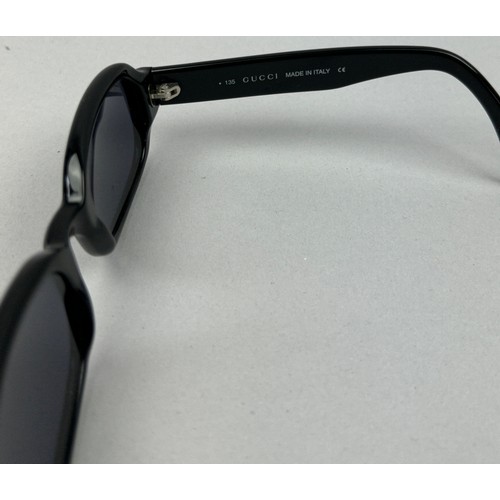 63 - TWO PAIRS OF BLACK GUCCI SUNGLASSES, both with Gucci emblems on each side