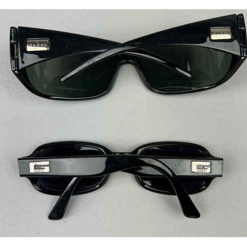 63 - TWO PAIRS OF BLACK GUCCI SUNGLASSES, both with Gucci emblems on each side