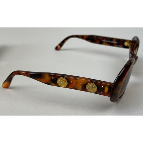 69 - THREE GIANNI VERSACE TORTOISESHELL DESIGN SUNGLASSES, all with gold 'Medusa head' detailing.