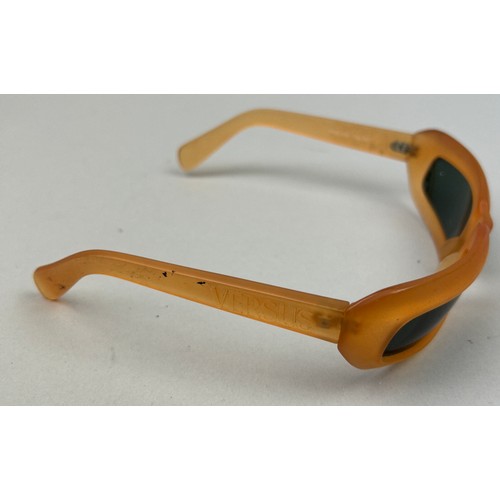 70 - A SET OF THREE VERSUS VERSACE SUNGLASSES, two orange and another with black frames and grey rims.

S... 