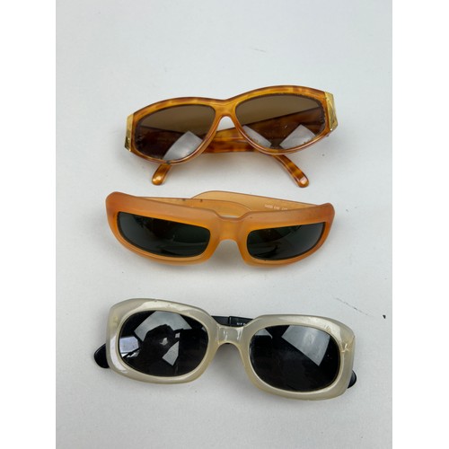 70 - A SET OF THREE VERSUS VERSACE SUNGLASSES, two orange and another with black frames and grey rims.

S... 