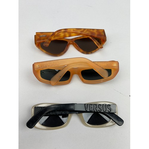 70 - A SET OF THREE VERSUS VERSACE SUNGLASSES, two orange and another with black frames and grey rims.

S... 