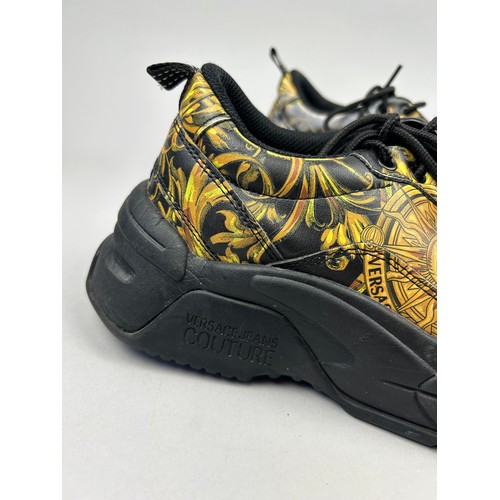 102 - A PAIR OF VERSACE TRAINERS IN BLACK AND GOLD, with 'Medusa heads' on each. 

Some marks