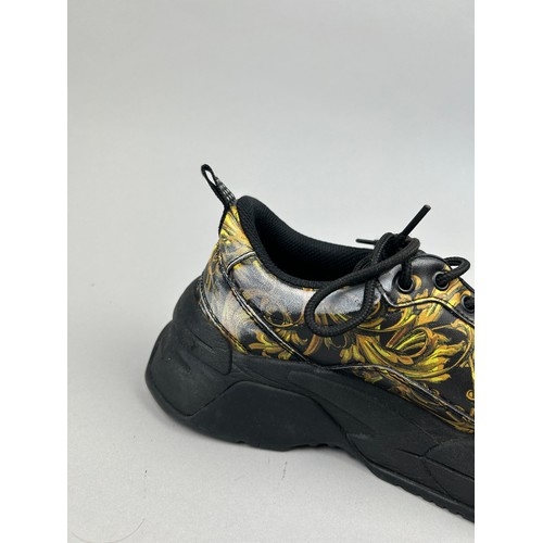 102 - A PAIR OF VERSACE TRAINERS IN BLACK AND GOLD, with 'Medusa heads' on each. 

Some marks