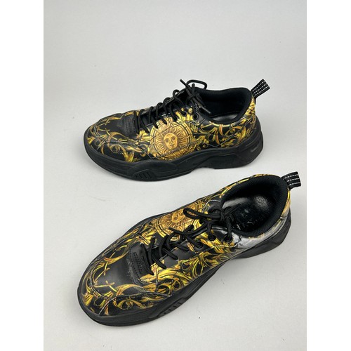 102 - A PAIR OF VERSACE TRAINERS IN BLACK AND GOLD, with 'Medusa heads' on each. 

Some marks