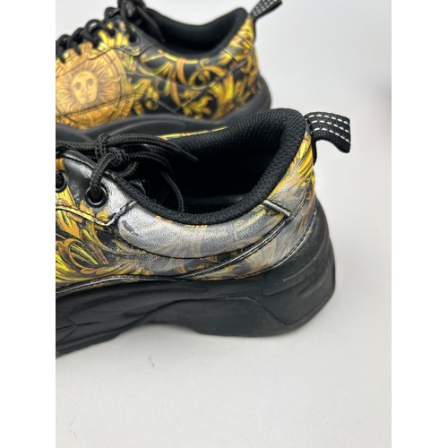 102 - A PAIR OF VERSACE TRAINERS IN BLACK AND GOLD, with 'Medusa heads' on each. 

Some marks