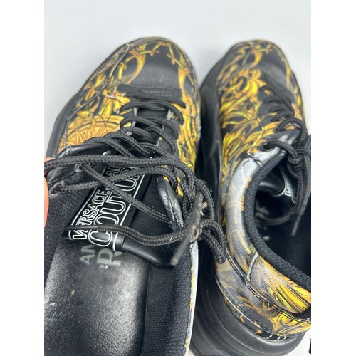 102 - A PAIR OF VERSACE TRAINERS IN BLACK AND GOLD, with 'Medusa heads' on each. 

Some marks