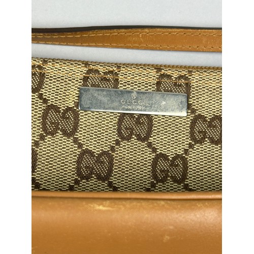 21 - A SMALL GUCCI SHOULDER BAG IN BEIGE, with interlocking 'GG' emblem throughout, tan leather strap and... 