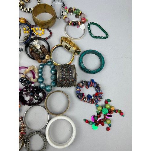 288 - A LARGE COLLECTION OF COSTUME BANGLES (Qty)