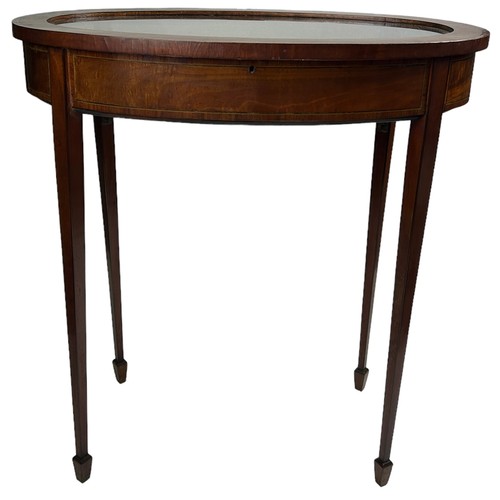 223 - AN EDWARDIAN MAHOGANY BIJOUTERIE TABLE, with satinwood veneer. Hinged glass top, raised on four tape... 