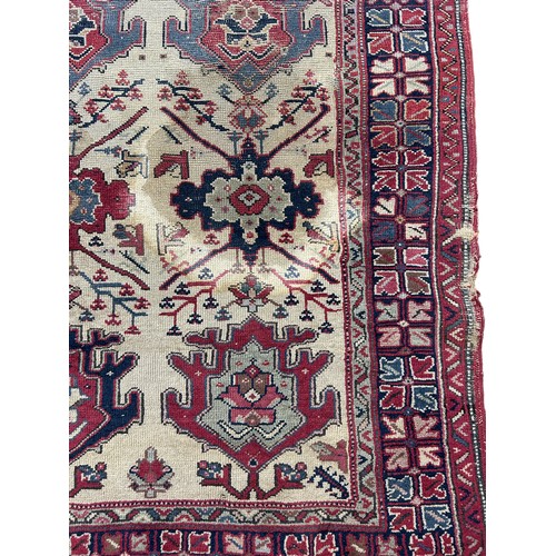 249 - AN ANTIQUE PERSIAN RUG, 

With signs of wear and marks throughout.

225cm x 125cm

**Please note thi... 