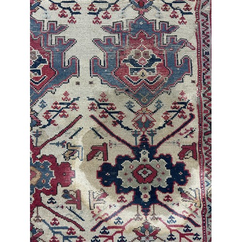 249 - AN ANTIQUE PERSIAN RUG, 

With signs of wear and marks throughout.

225cm x 125cm

**Please note thi... 