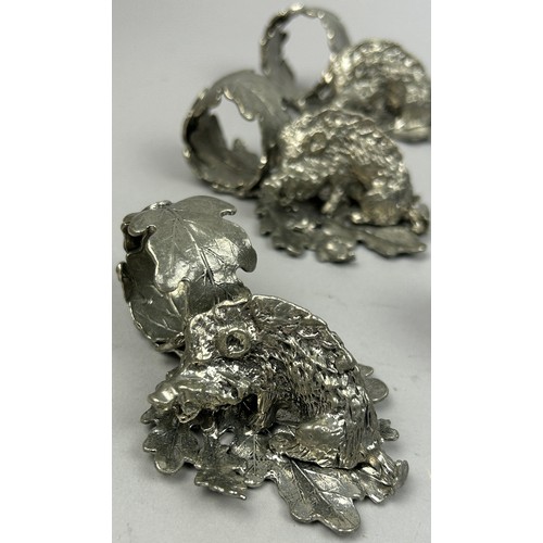 122 - A SET OF NINE SILVER PLATED NAPKIN RINGS REALISTICALLY FIGURED IN THE FORM OF HOGS ON LEAVES, in the... 