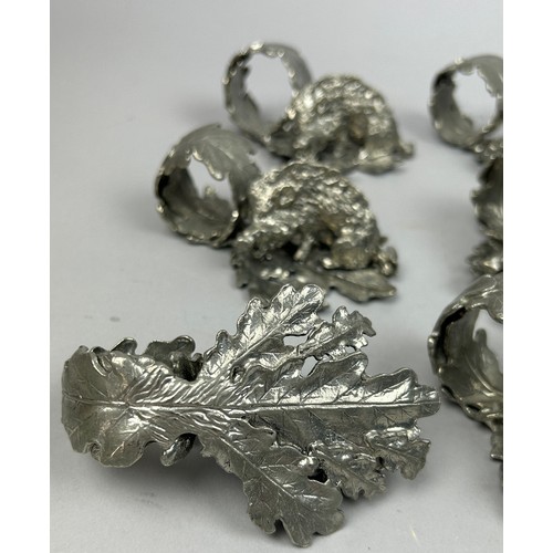 122 - A SET OF NINE SILVER PLATED NAPKIN RINGS REALISTICALLY FIGURED IN THE FORM OF HOGS ON LEAVES, in the... 