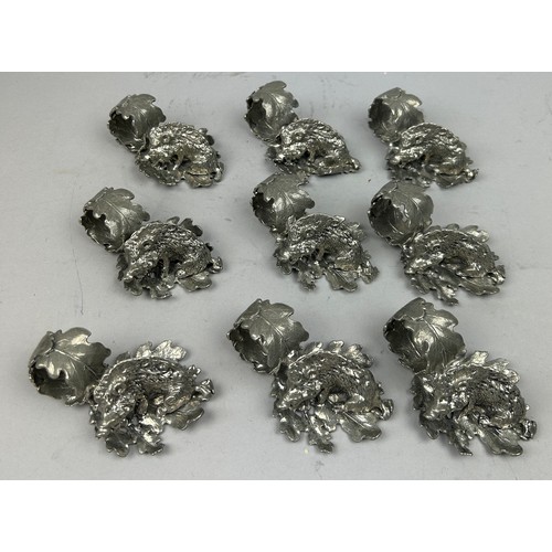 123 - A SET OF NINE SILVER PLATED NAPKIN RINGS REALISTICALLY FIGURED IN THE FORM OF HOGS ON LEAVES, in the... 