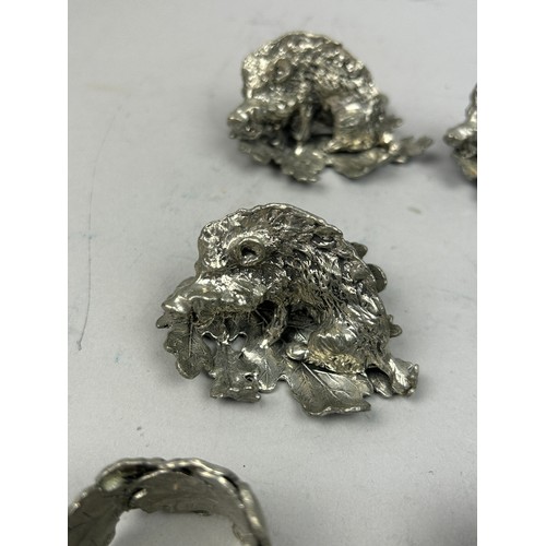 124 - A SET OF FIVE SILVER PLATED NAPKIN RINGS REALISTICALLY FIGURED IN THE FORM OF HOGS ON LEAVES, in the... 