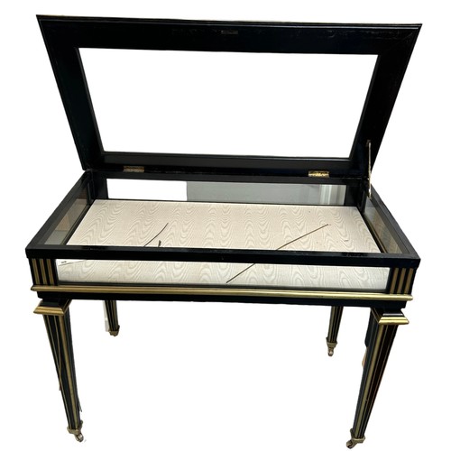 221 - AN EBONISED AND BRASS VITRINE TABLE, late 19th Century. With hinged top, silk lining, raised on flut... 