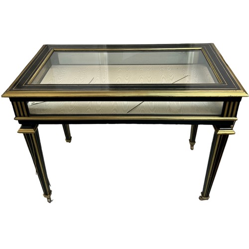 221 - AN EBONISED AND BRASS VITRINE TABLE, late 19th Century. With hinged top, silk lining, raised on flut... 