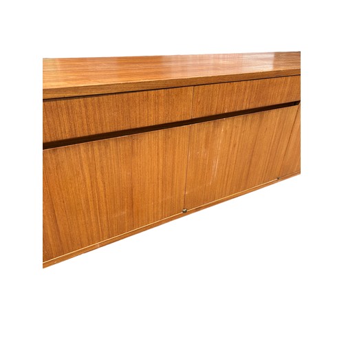 243 - A MID CENTURY TEAK SIDEBOARD, four opening compartments and two central drawers. 

The compartments ... 