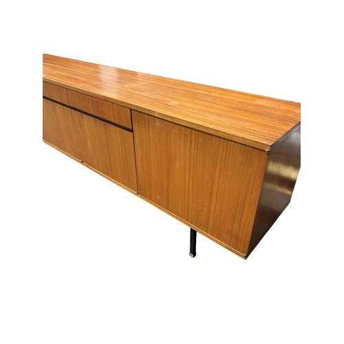 243 - A MID CENTURY TEAK SIDEBOARD, four opening compartments and two central drawers. 

The compartments ... 