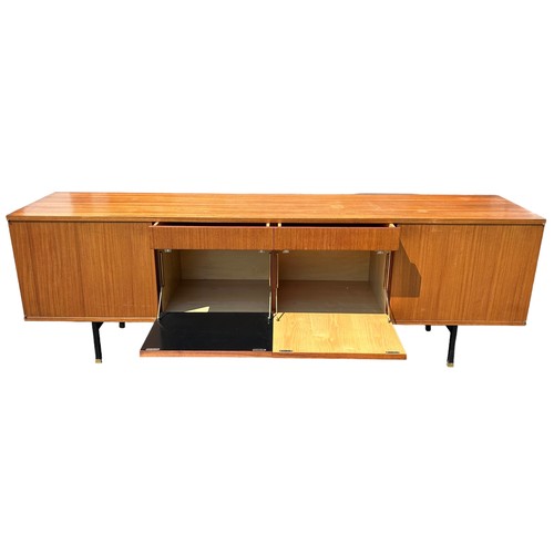 243 - A MID CENTURY TEAK SIDEBOARD, four opening compartments and two central drawers. 

The compartments ... 