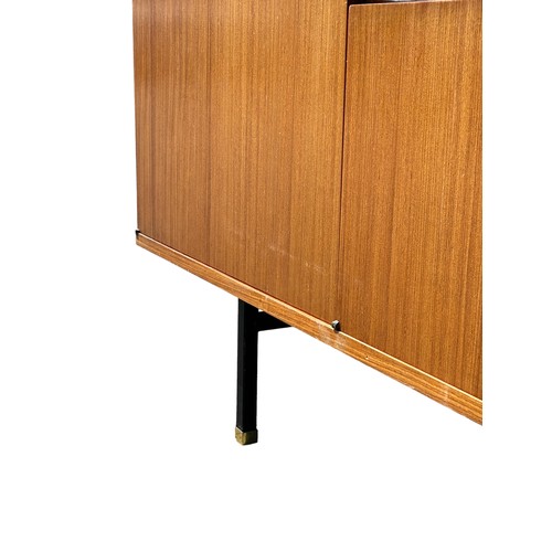 243 - A MID CENTURY TEAK SIDEBOARD, four opening compartments and two central drawers. 

The compartments ... 