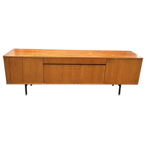 243 - A MID CENTURY TEAK SIDEBOARD, four opening compartments and two central drawers. 

The compartments ... 