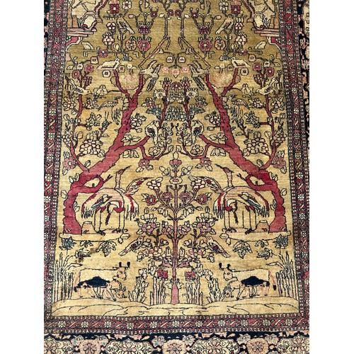 205 - A FINE TURKISH PICTORIAL RUG DEPICTING SMALL BIRDS CRANES AND CATTLE WITH FOLIATE BORDER

205cm x 13... 