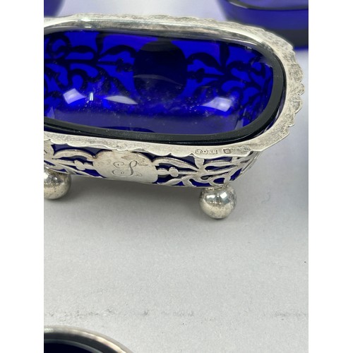 65 - A COLLECTION OF SILVER SALT CELLARS AND MUSTARD POTS, each with blue glass inserts (7) 

The salt ce... 