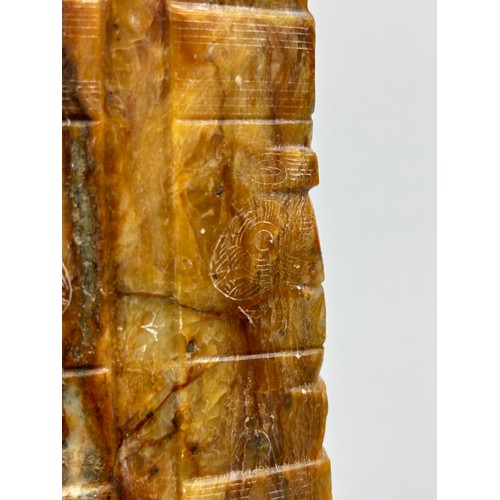 72 - A CHINESE HARDSTONE OR JADE TALL VESSEL OF ARCHAIC FORM, incised with various symbols and marks. 

2... 