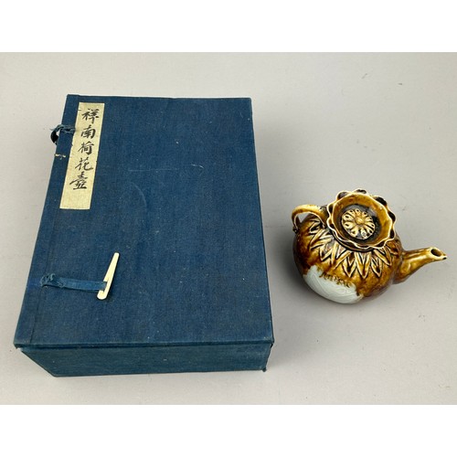 69 - A CHINESE BROWN GLAZED TEA POT IN BLUE CLOTH BOUND CASE, with calligraphy to front

13cm x 11cm