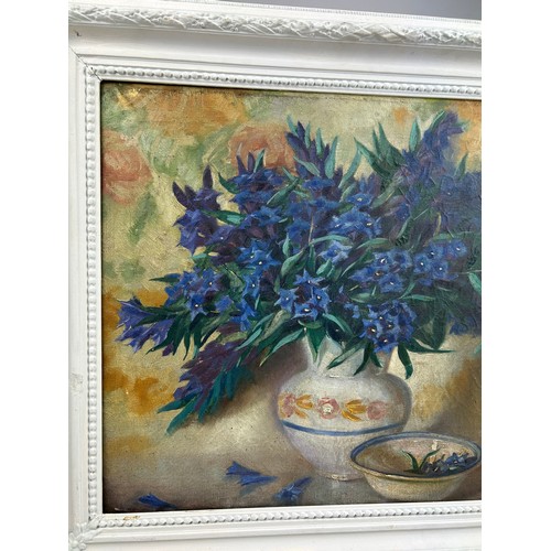 171 - AN OIL ON CANVAS STILL LIFE OF BLUE FLOWERS IN A VASE, mounted in a white frame. 

Signed indistinct... 