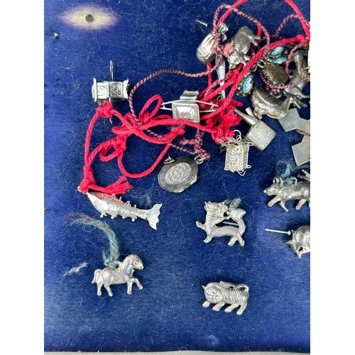 54 - AN UNUSUAL COLLECTION OF CHINESE SILVER CHARMS, 

To include dragon, tiger, sedan chair and many oth... 