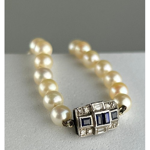 7 - A LONG-CULTURED PEARL NECKLACE WITH WHITE GOLD CLASP, INSET WITH SMALL DIAMONDS AND SAPPHIRES 

Weig... 