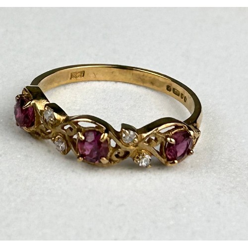 28 - A 9CT GOLD RING INSET WITH THREE SMALL RUBIES AND FOUR SMALL DIAMONDS