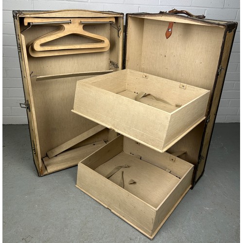 513 - A LARGE BEIGE TRAVEL WARDROBE TRUNK WITH FITTED INTERIOR