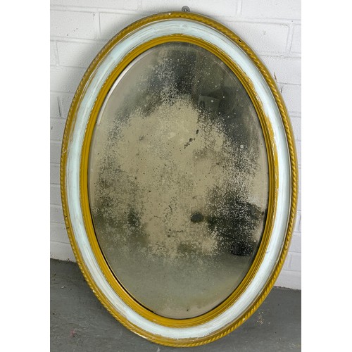 518 - AN OVAL WALL MIRROR GILTWOOD PAINTED WITH MOTTLED GLASS