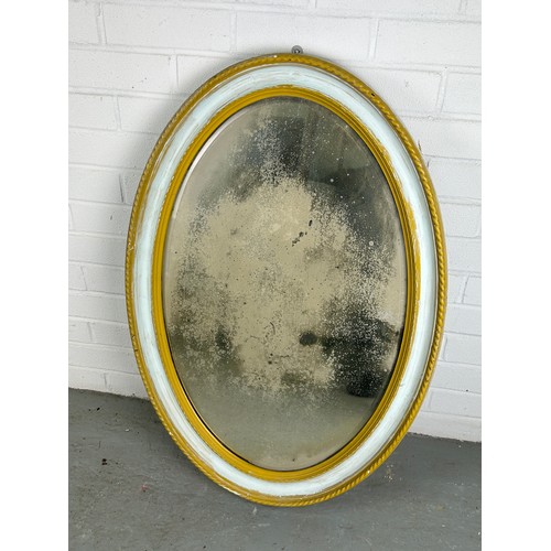 518 - AN OVAL WALL MIRROR GILTWOOD PAINTED WITH MOTTLED GLASS