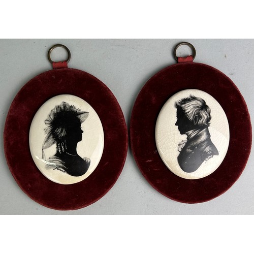 414A - A PAIR OF CERAMIC SILHOUETTES ON RED VELVET (2)