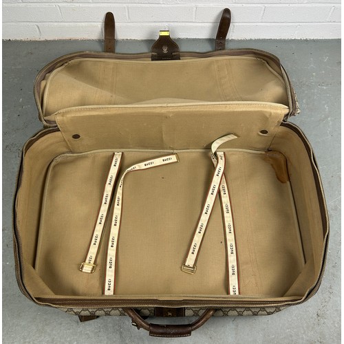 359A - GUCCI LUGGAGE: A VINTAGE GUCCI SUITCASE,

Gucci monogram throughout with brown stitched leather stra... 