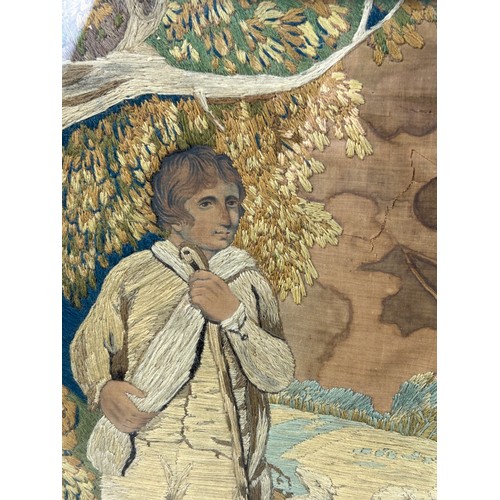 394A - A GEORGIAN PICTORAL WOOL WORK DEPICTING A YOUNG MAN WITH A DOG, 

Possibly late 18th century.